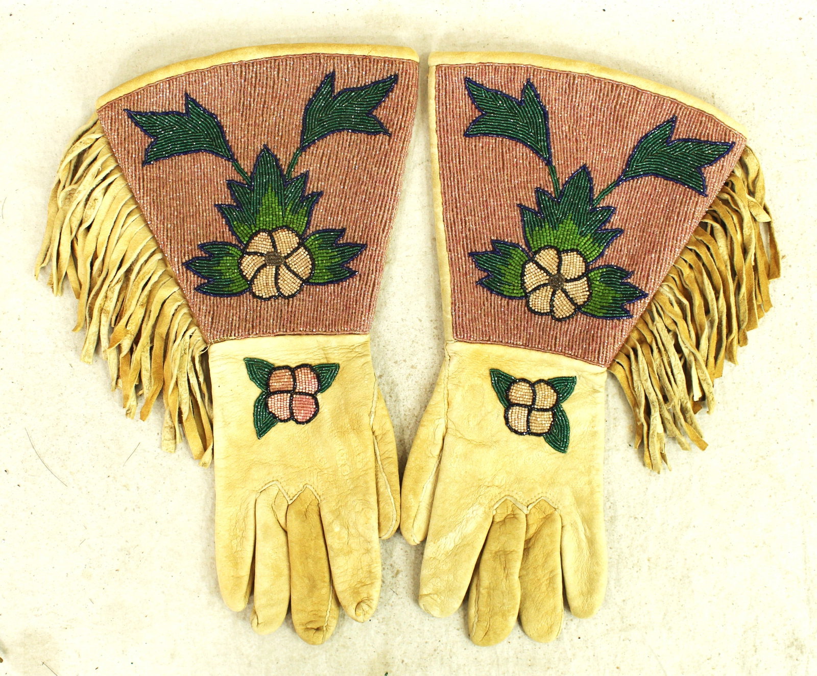 Plateau Beaded Gauntlets: An interesting Nez Perce Indian made, fully beaded gauntlets, using uncommon cut glass taupe colored beaded background and contrasted with a floral pattern. In excellent condition.