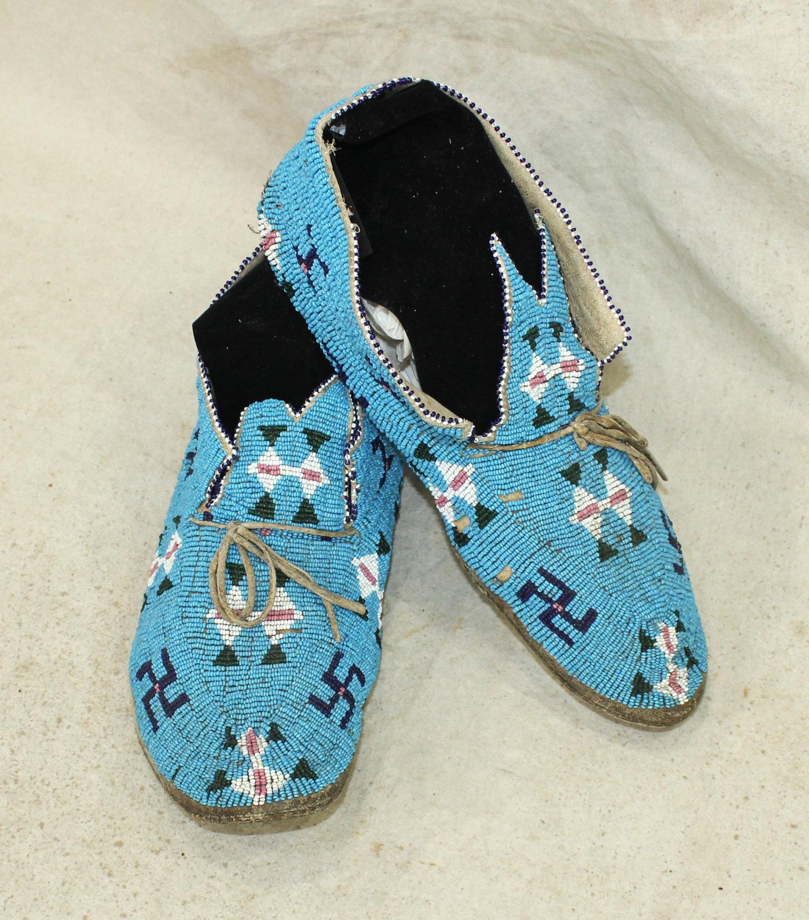 Cheyenne Moccasins: A great looking pair of pre-1900 Northern Plains moccasins, with an uncommon pattern of rolling logs on a light blue background. In very nice condition.