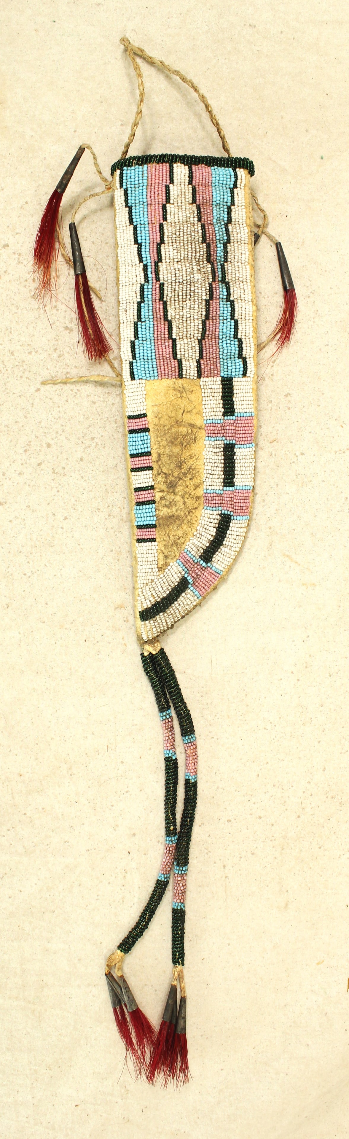 Northern Plains Beaded Knife Sheith: An extra large 1800's Crow Indian knife sheath with attractively beaded geometric pattern throughout, adorned by two terrific beaded drops, and decorative tinkle cones.