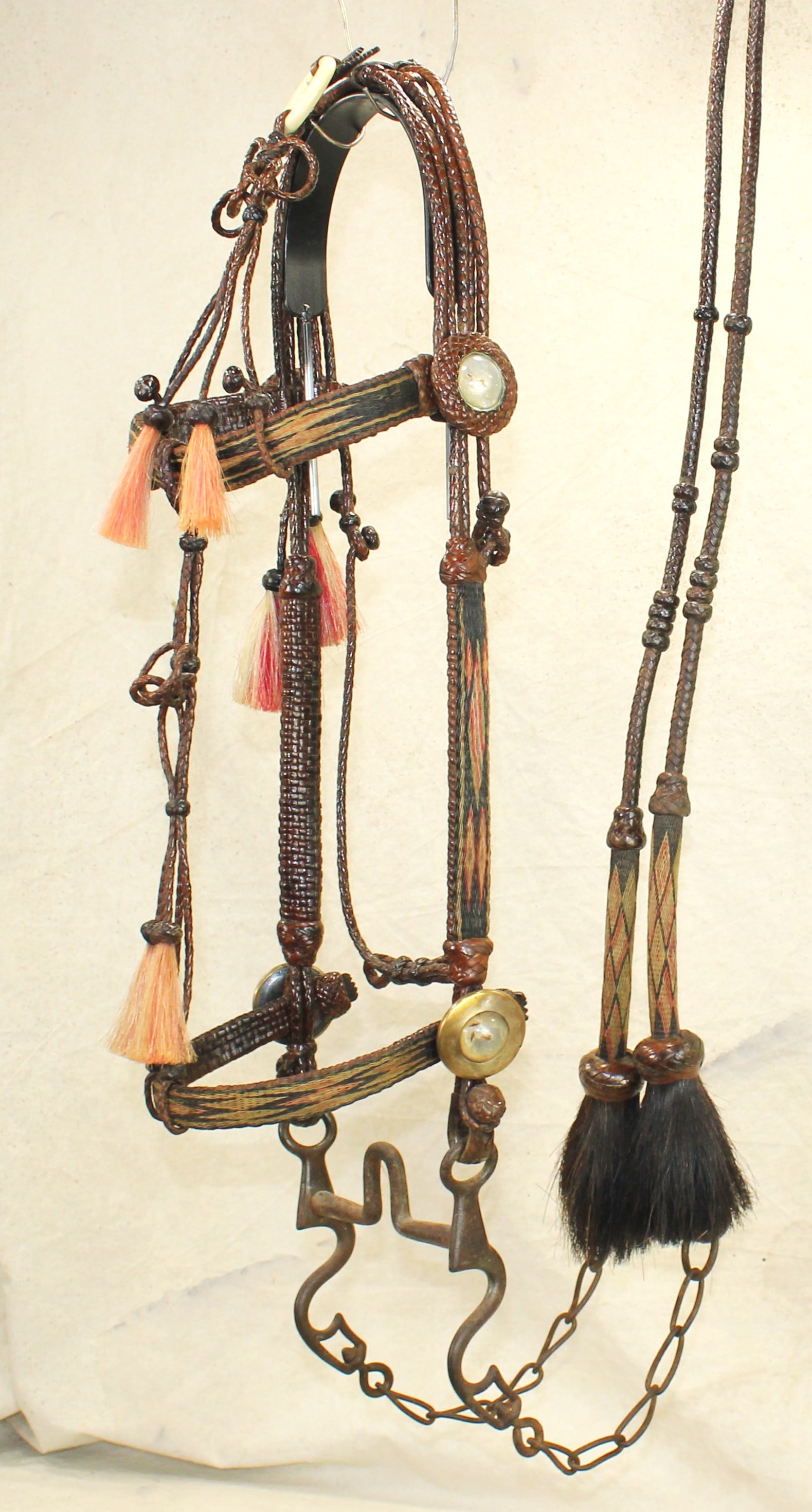 Rawlins Wyoming Horsehair Bridle: A wonderful display of craftsmanship, this hitched horsehair bridle shows bright geometrics on a black background, backed by finely braided leather, highlighted by red tassles, exceptional split reins