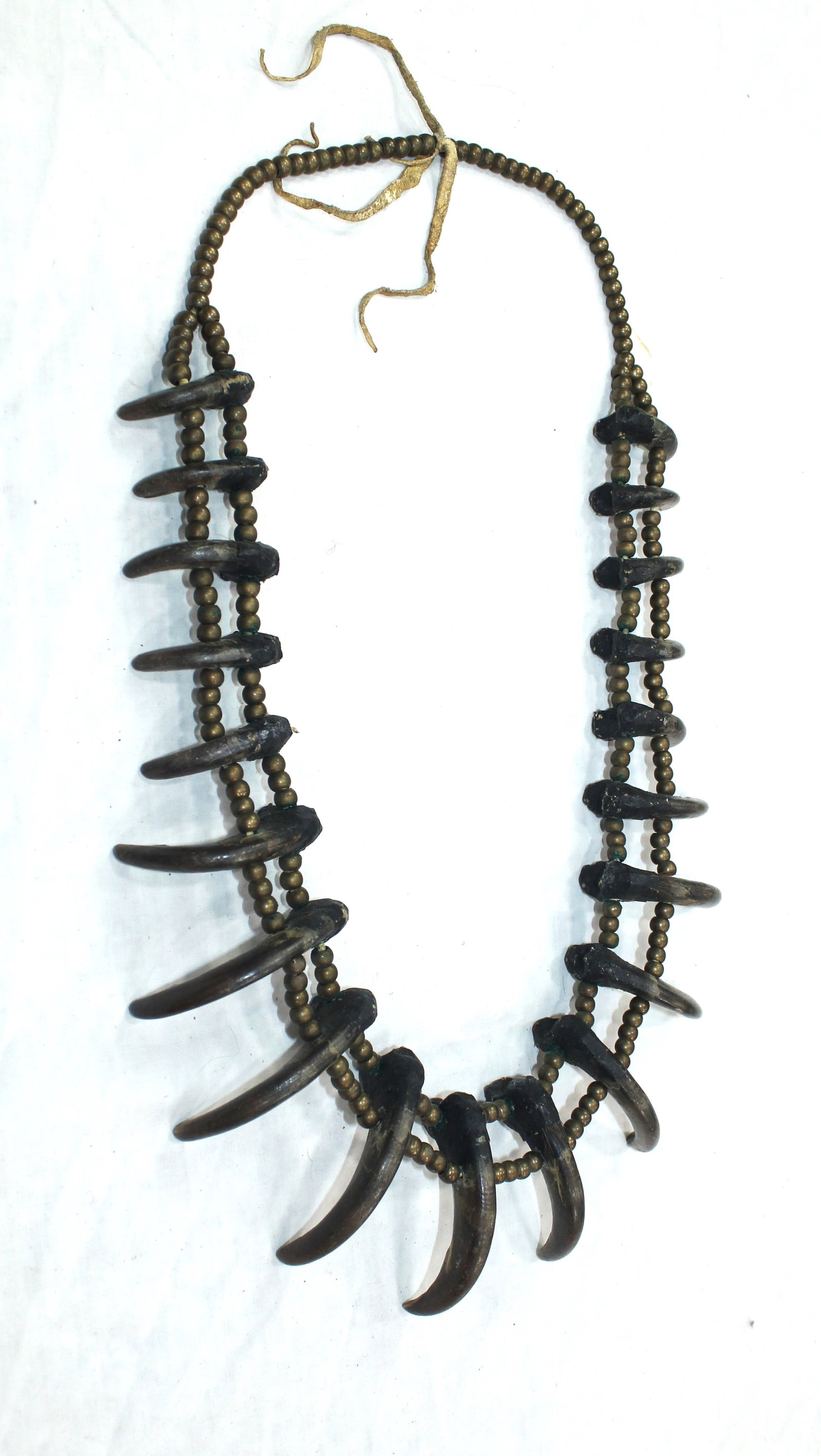 Crow Bear Claw Necklace: This is an incredible piece of Native American culture, and authentic 1880's bear claw neacklace with a beautiful design of graduated claws, and a fantastic double row of brass beads. Showing wonderfu