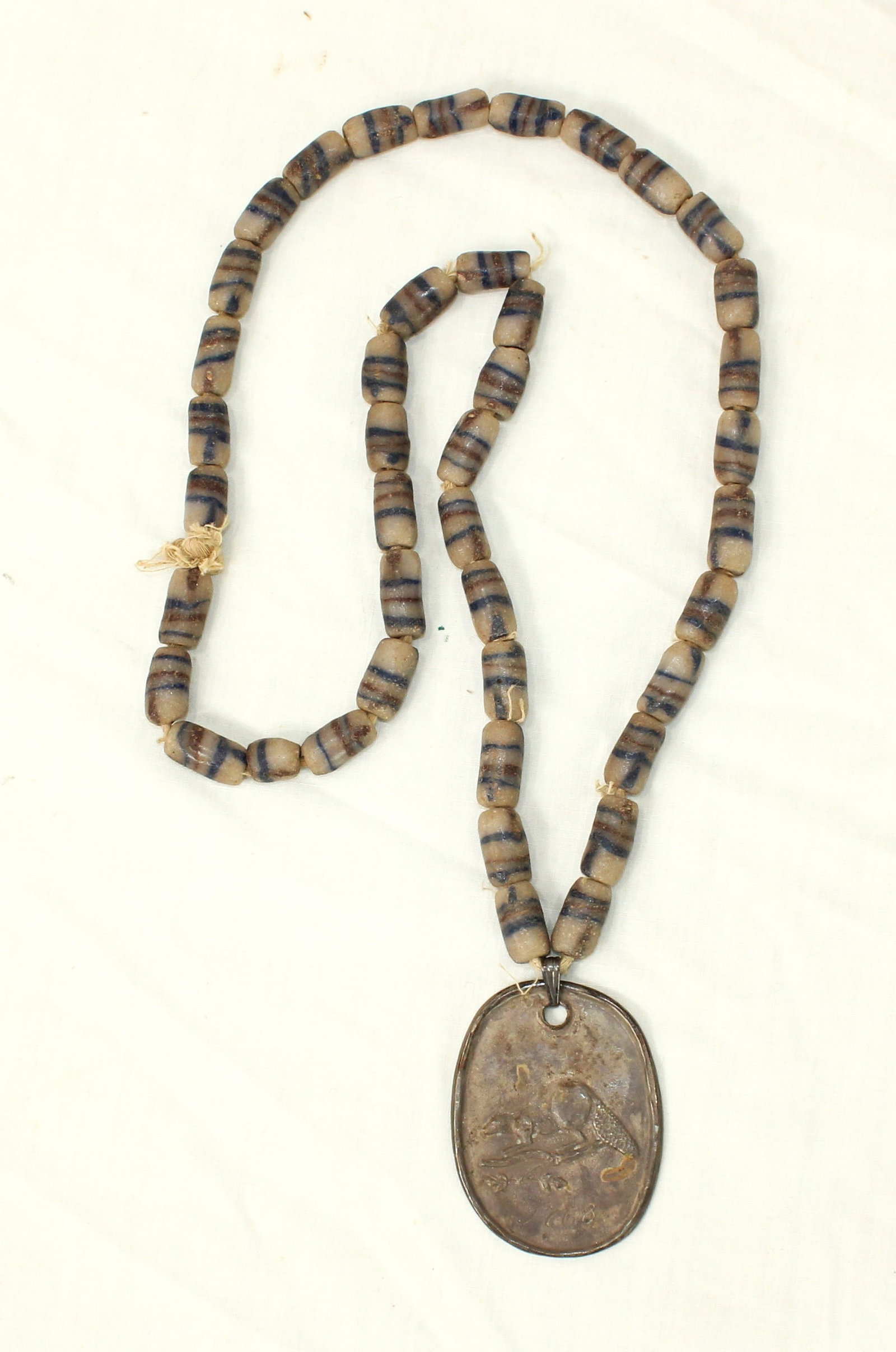 Incredible French Medallion Necklace: A beautiful fur trade strung bead neacklace, centered around an interesting very early Peace Medal style medallion appearing to be made of silver, with a moulded image of a beaver on one side and insc