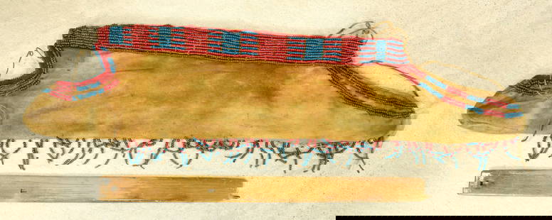 A 19th century Blackfoot Indian buffalo hide quiver, trimmed in pony style glass beads, showing: A 19th century Blackfoot Indian buffalo hide quiver, trimmed in pony style glass beads, showing great age and color.