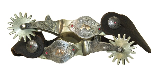 Striking pair of large single mounted spurs with nicely engraved full overlay focusing on a gold