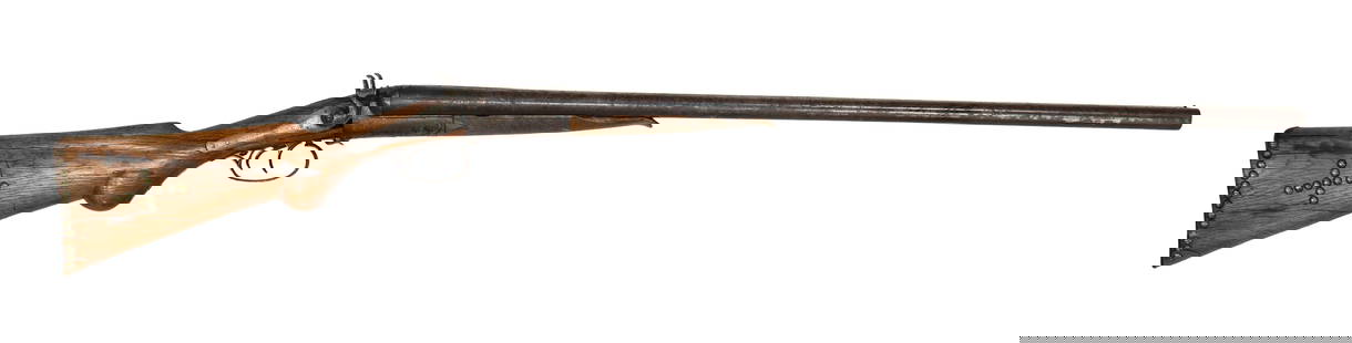 Indian Tacked Shotgun: A percussion double barrel, side by side shotgun, in 12 gauge, marked J.D. & Co. on the lock, displaying a checkered oak stock with brass tack design, and 30&#8221; barrels showing mottled patina colo