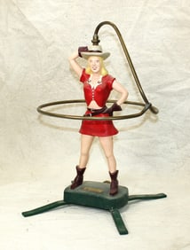 Terrific vintage cast metal lawn sprinkler fasioned as a stylish cowgirl twirling a rope. Dimensions