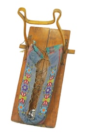 Hardwood cradleboard with floral beaded calico cloth papoose setion. Retains sun shade cover frame.