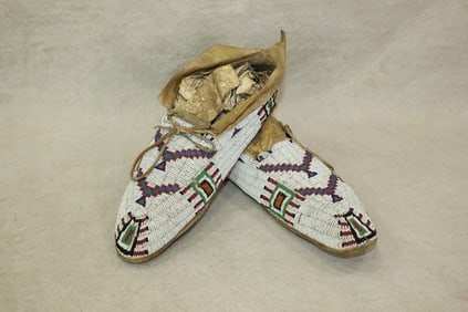 A large pair beautifully beaded sioux moccasins on brain tanned hide, with unique toe pattern on