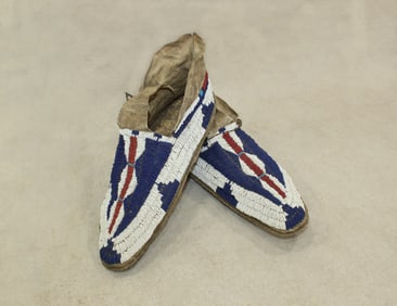 An extra nice pair of large Plains Indian moccasins fully beaded with striking colors and design on