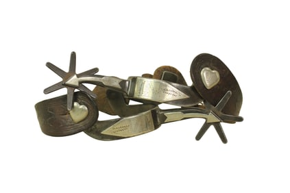 A tremendous pair of detail engraved single mounted arrow shank spurs with heart buttons, giant six