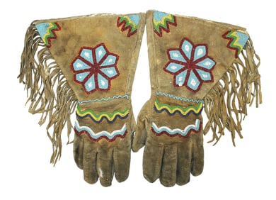 Heavy hide gloves with brightly beaded star pattern and long fringe.