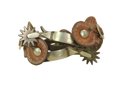 A single mounted pair of iron spurs with distinctive Crockett engraving, large rowels and period