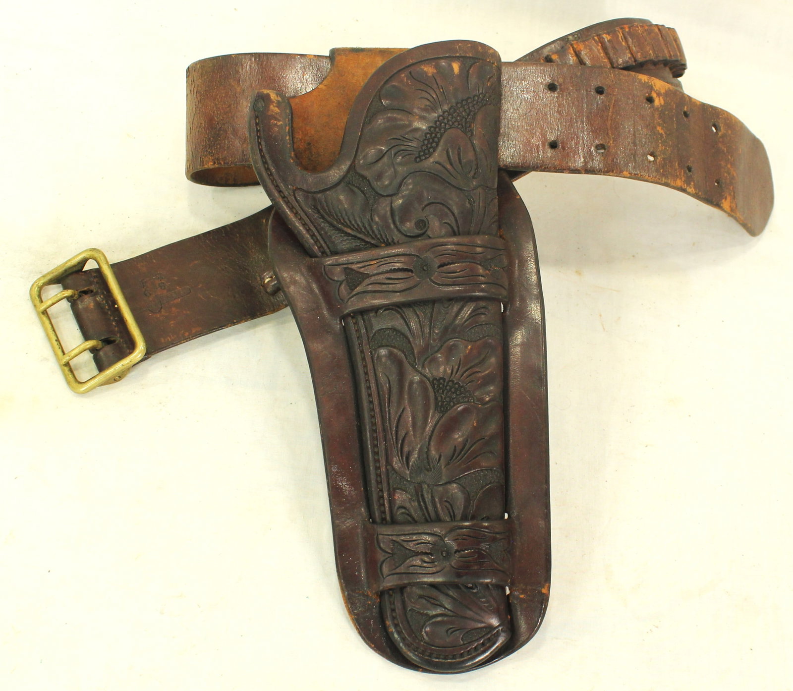 Heiser Gun Rig: Fully flower tooled 7 ½” double loop holster fitting a single action Colt revolver, mounted on cartridge belt featuring large caliber loops and period western styling. Both nicely maker