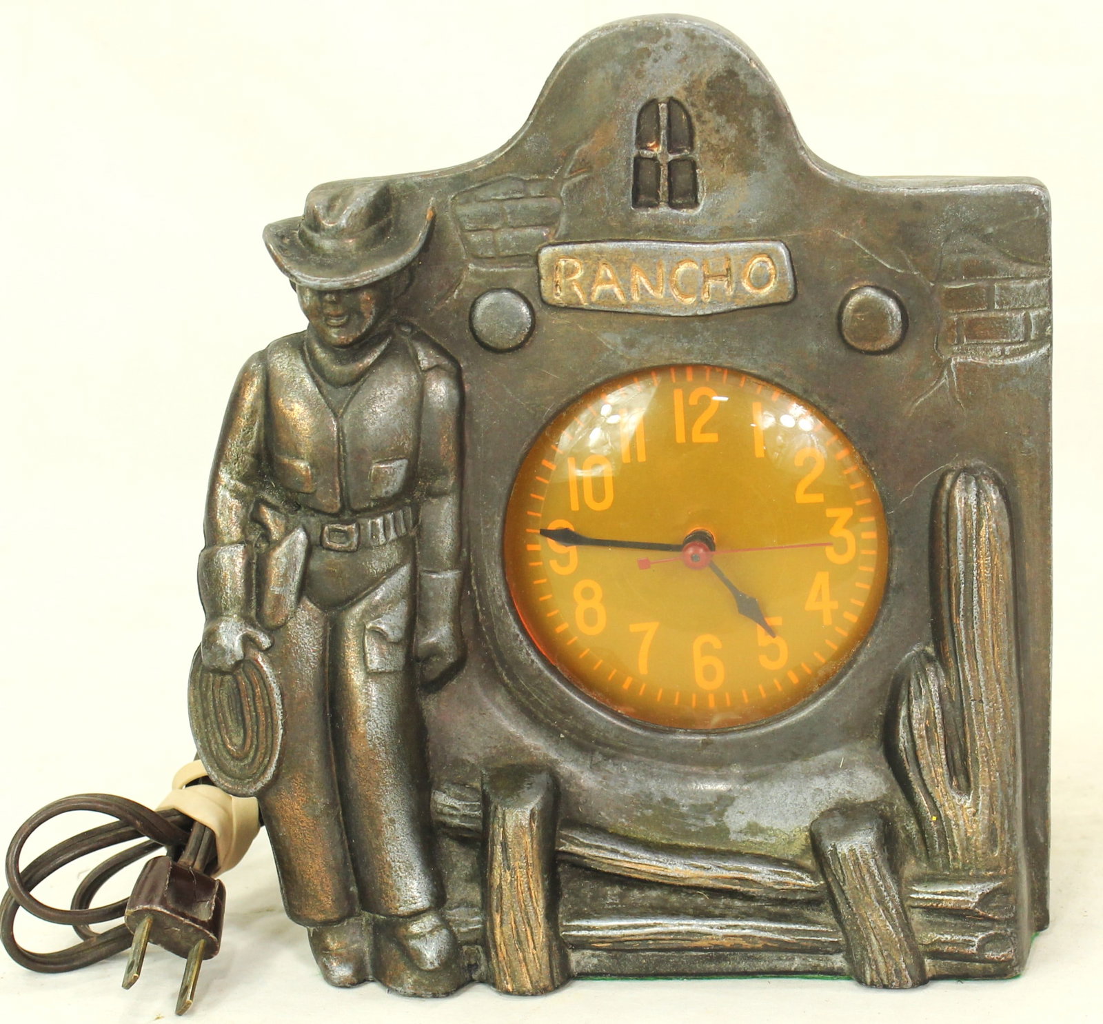 Antique Rancho Cowboy Clock: Western-themed 1930’s electric clock depicting cowboy, ranch scene, and cactus motif, in working condition. Decorative mid-century western collectible.