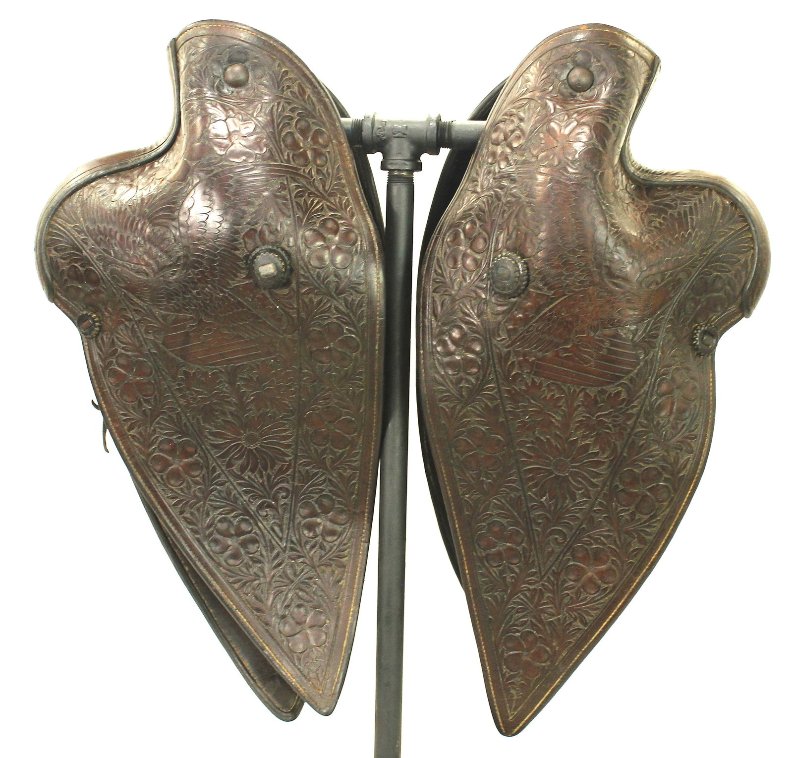 Desirable Hand Carved Tapaderos: Pair maker marked J. Oui Jada, San Jose made tapaderos, with heavily figural carved leather displaying elaborate floral decoration and eagles. An outstanding example of traditional Western leather