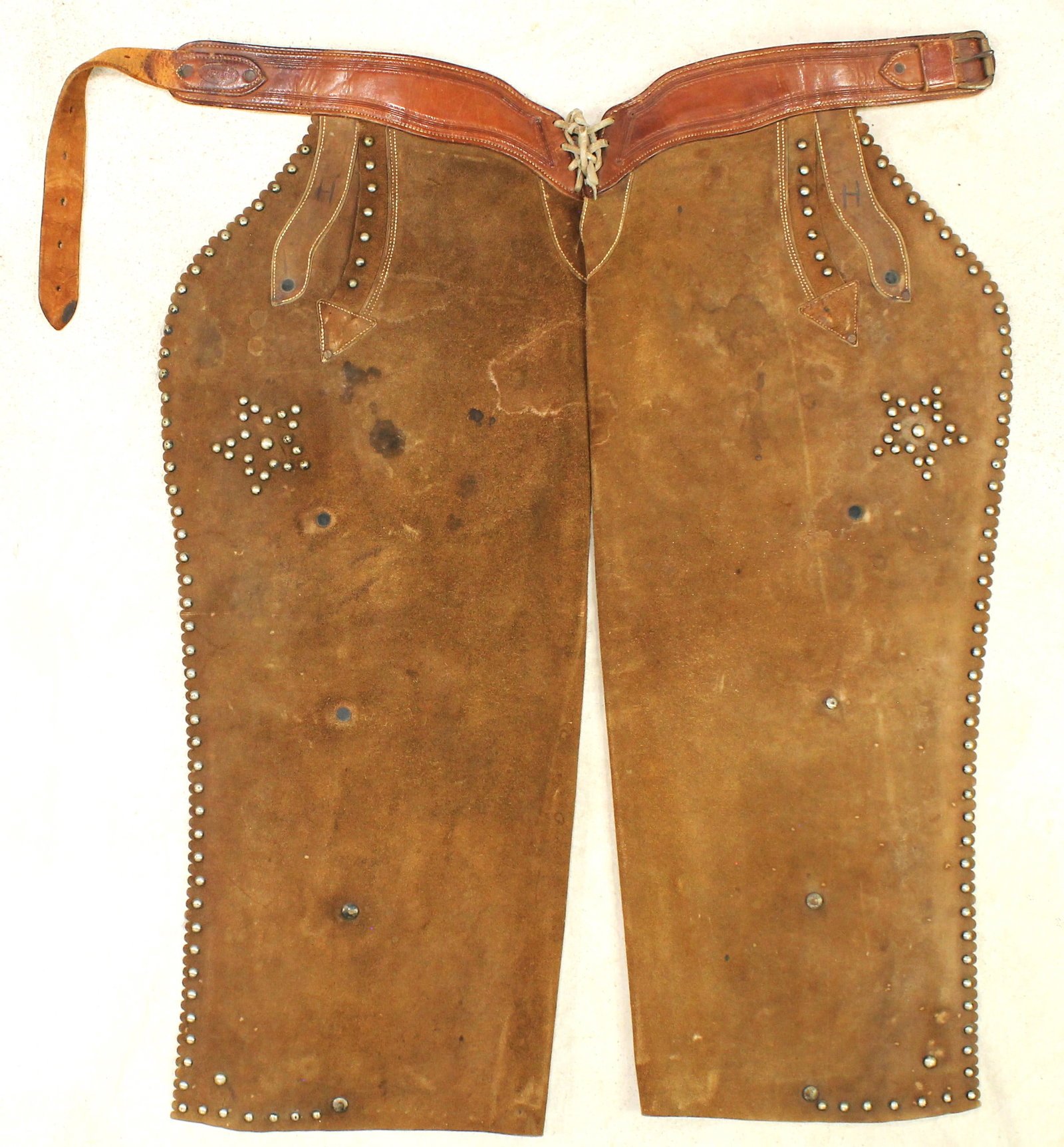 Miles City Saddlery Chaps: Uncommon batwing chaps from a great Montana maker, with light color and decoratively studded perimeter. Showing very little use, and nicely marked on the belt.
