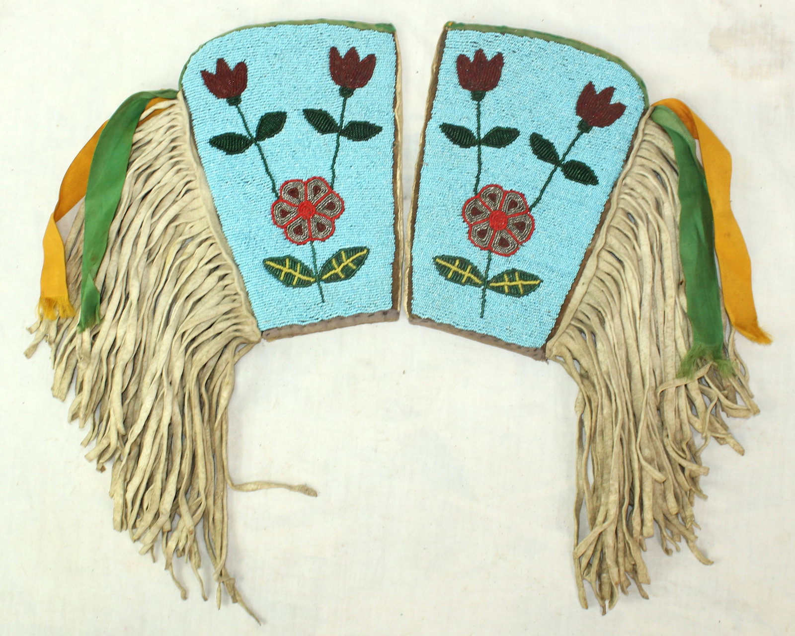 Beaded Indian Cuffs: Colorful beaded Blackfoot cuffs, decorated with floral motifs and accented by long fringe and silk ribbon streamers. Carefully executed craftsmanship with attractive color palette. Ideal for display w