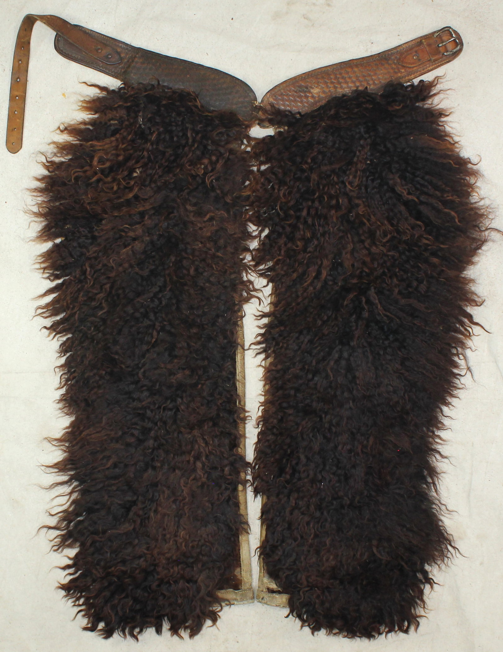Brown Angora Chaps: An attractive pair of brown angora step-in chaps, displaying thick curly hair, a basket stamped belt, and nice condition. With strong visual appeal and authentic cowboy character.