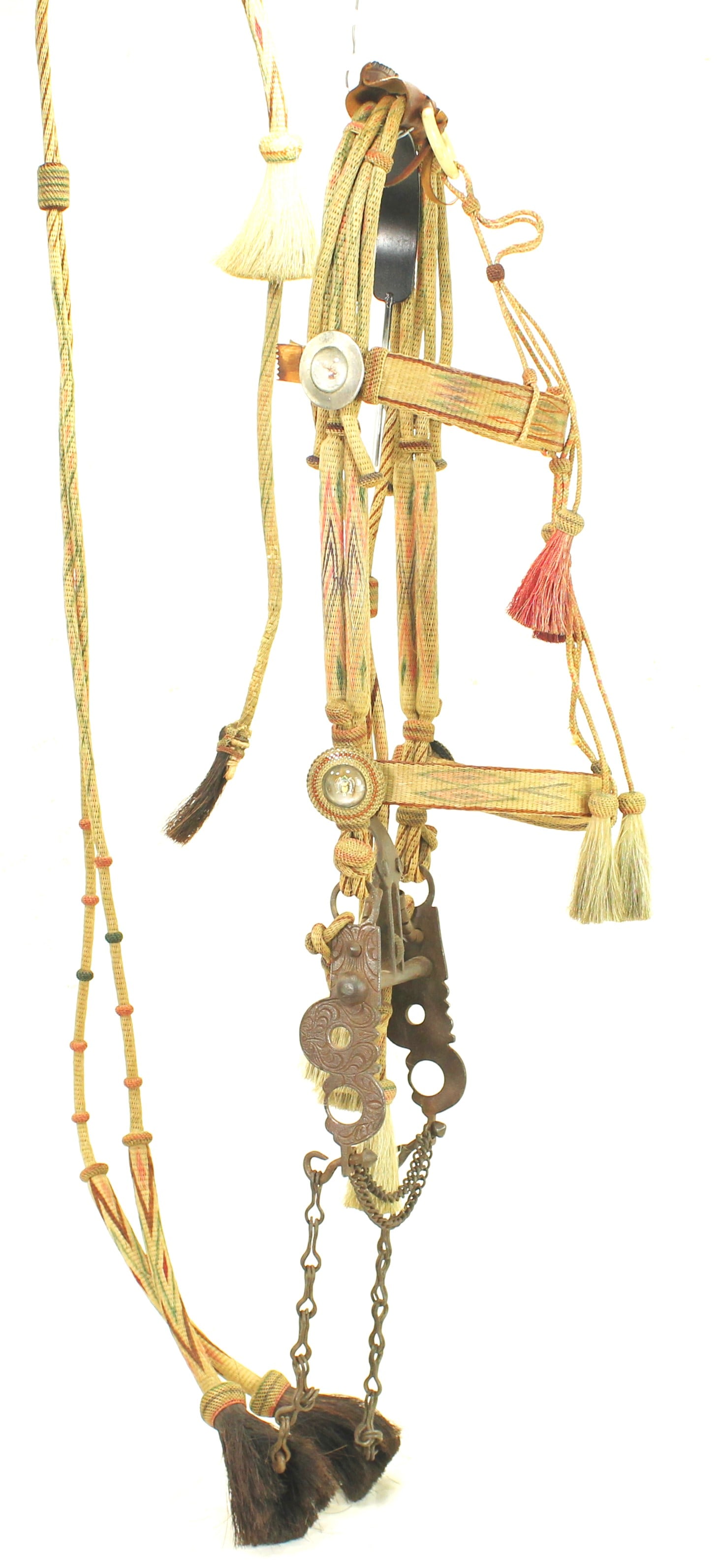 Deerlodge Prison Horsehair Bridle: Brightly colored bridle featuring intricate hitched horsehair, decorative tassels, nice grass rosettes, romel reins complete with removable quirt, and scarce original bit. Exhibiting a seldom seen