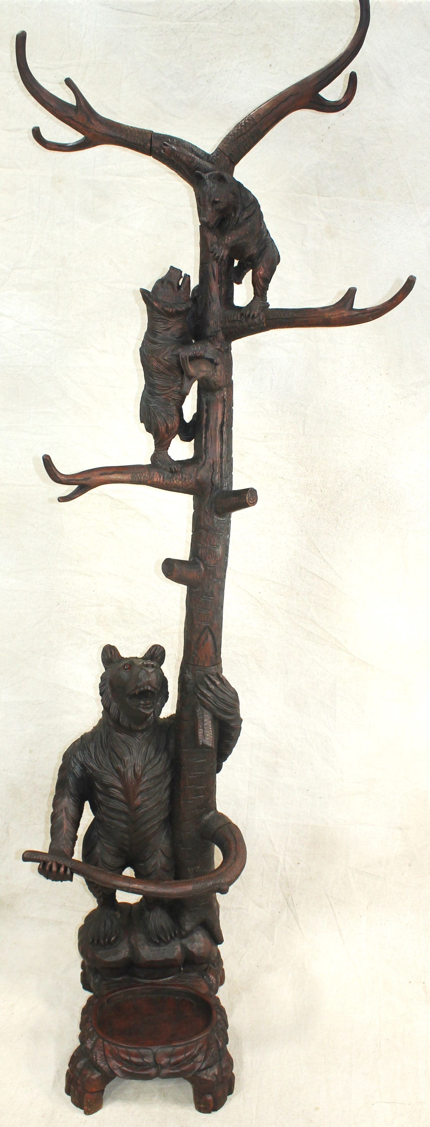 Black Forest Style Bear Halltree: Impressive rustic hall tree featuring a carved standing bear at the base of the tree, with additional carved bears climbing the tree branches. Incorporates umbrella or cane stand at base. Executed in 