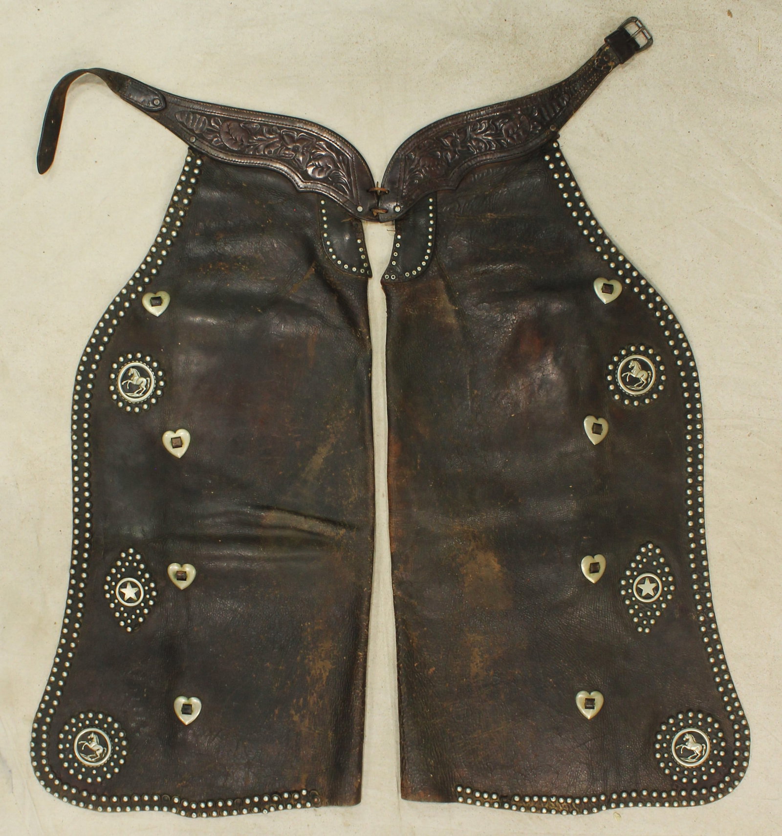 Rare Hamley Studded Batwing Chaps: Extremely rare batwing chaps from one of collecting’s more desirable maker’s. Displaying seldom seen filigreed silver horse conchos, accented by a dazzling pattern of nickel studs and hear