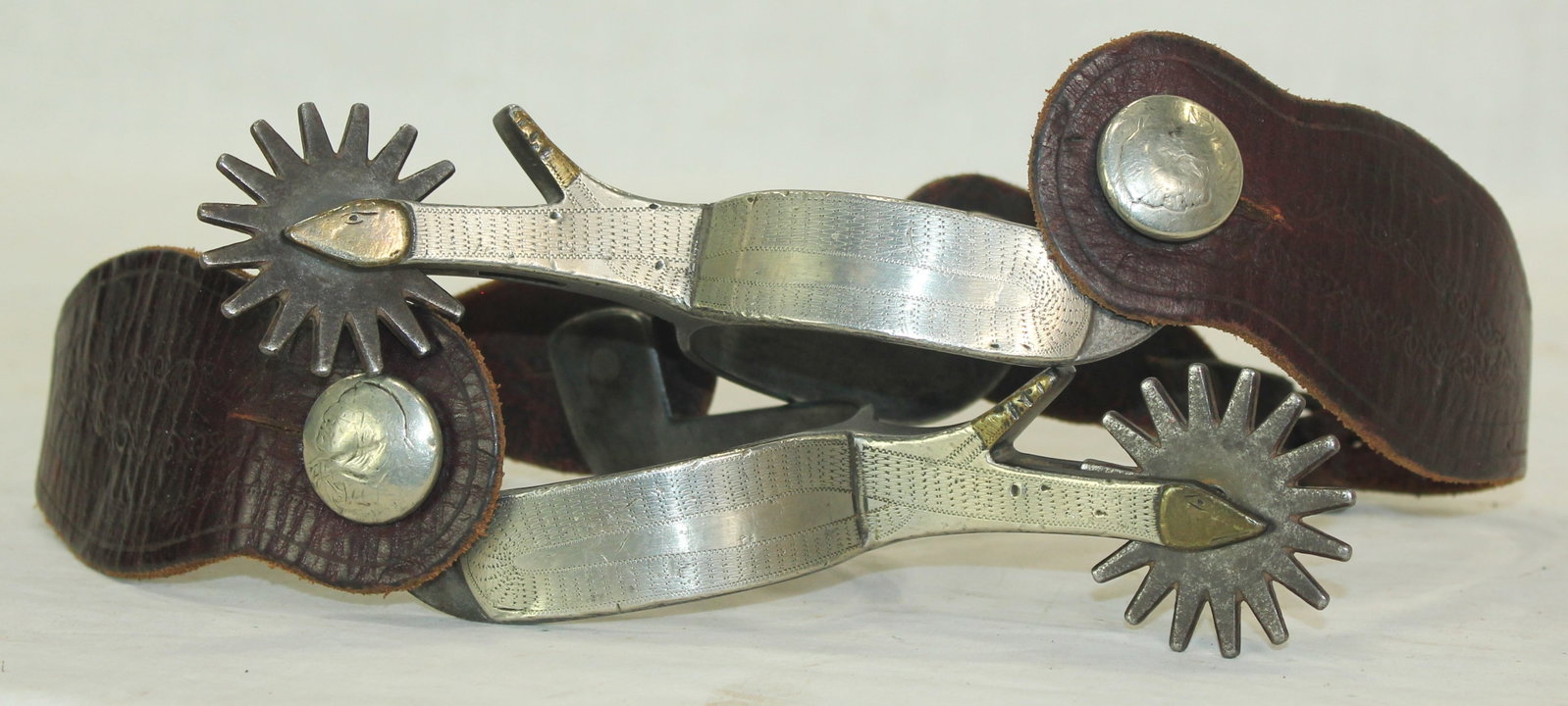 Kelly Bro's Rattlesnake Spurs: Incredibly rare pair of Texas style spurs, single mounted with a twisted rattlesnake motif, large multi-point rowel, Indian head nickel strap buttons, and nice straps.