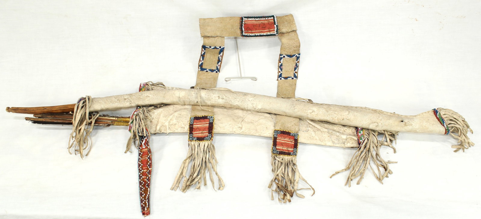 Northern Plains Bow and Quiver: An eye catching Pre-1900 bow and quiver set with attractive brain tanned hide, adorned with attractive beadwork, beautifully fringed ends, and completed by its original bow and 5 arrows.