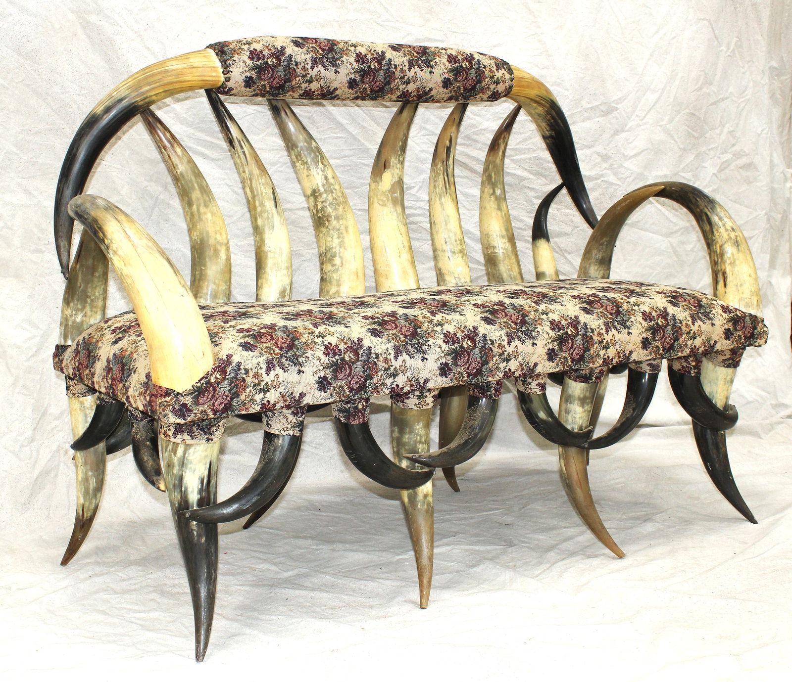Longhorn Bench: Custom vintage Western-style bench constructed from longhorn cattle horns with upholstered seat and back. Exceptional statement piece for ranch or lodge décor. Measuring 44”x 56”.
