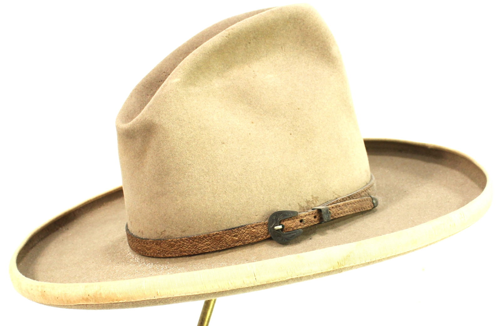 Vintage Cowboy Hat: Pleasing light-colored felt cowboy hat with simple leather hatband with silver buckle set, pencil rolled bound edge, 4” brim, 6” crown, and period Western styling.
