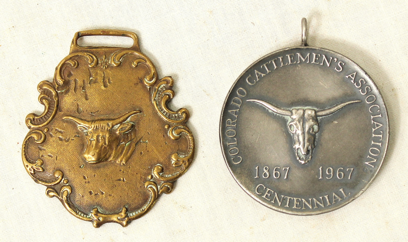 Grouping of Western Watch Fobs: A grouping of 2 collectible advertising watch fobs, one from Sigel Campion Livestock, and the other from Colorado Cattleman's Association.