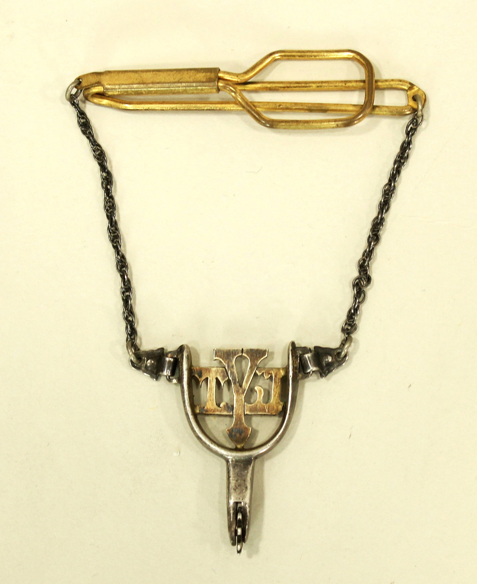 Holland Spur Tie Bar: A beautiful vintage figural tie bar in the shape of a spur, marked "Holland, and presumed to be silver and possibly gold.