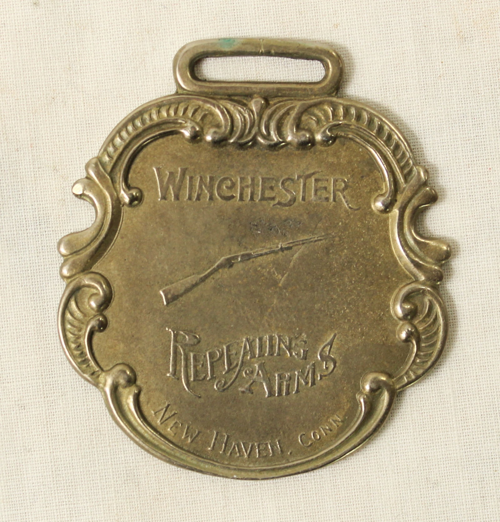 Antique Winchester Watch Fob: A sought after antique advertising watch fob, promoting Winchester Firearms, and marked sterling silver on the back.
