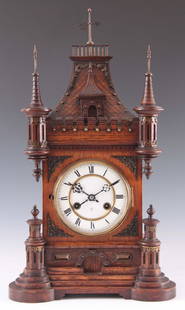 A LATE 19th CENTURY GERMAN OAK CASED MANTEL CLOCK: A LATE 19th CENTURY GERMAN OAK CASED MANTEL CLOCK the architectural style case surmounted by turrets and a weather vane enclosing a 5" two-piece porcelain dial fronting a spring driven eight-day strik