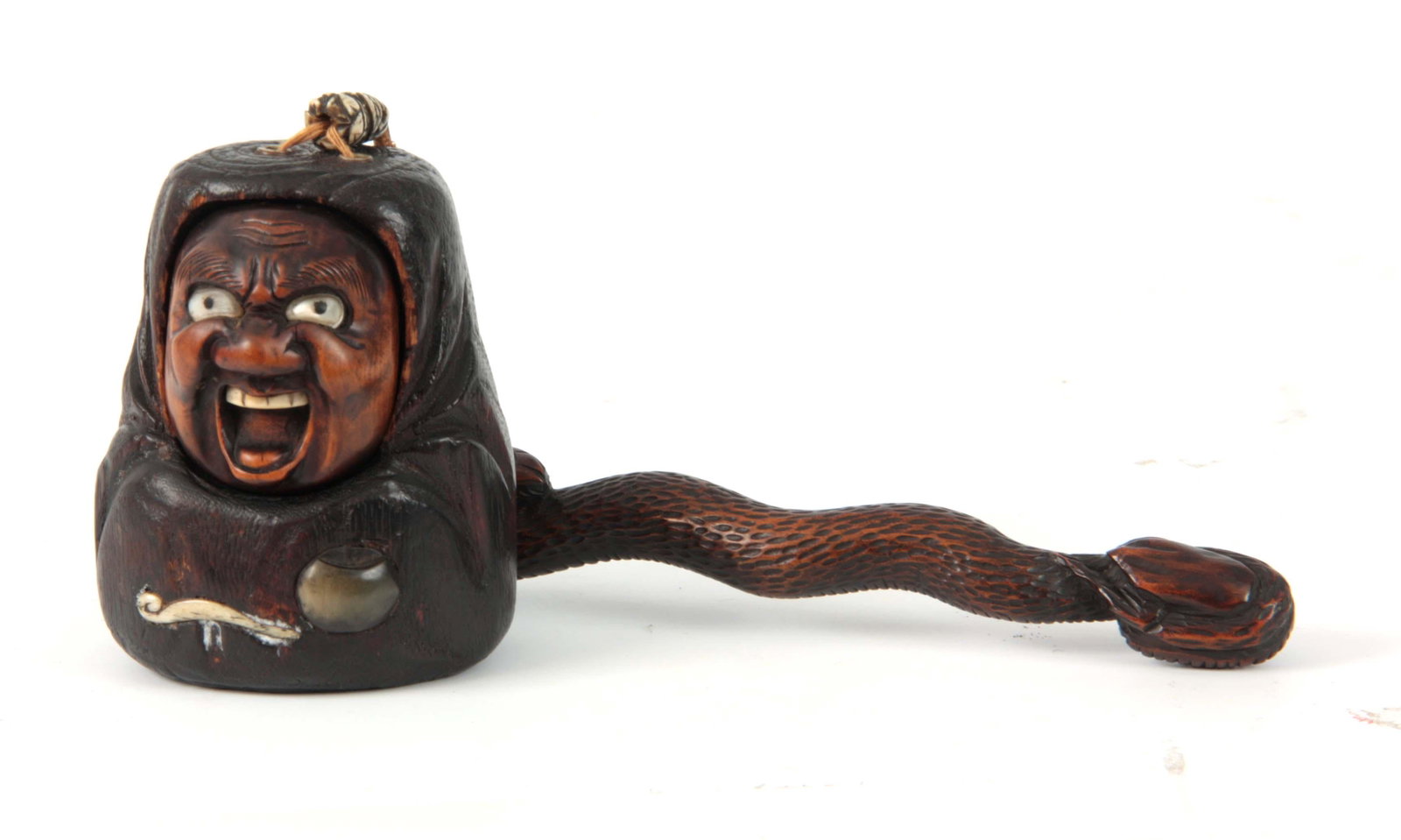 A MEIJI PERIOD JAPANESE TOBACCO POUCH AND PIPE HOL: A MEIJI PERIOD JAPANESE TOBACCO POUCH AND PIPE HOLDER the carved wooden lid formed as a grotesque mask with mother-of-pearl eyes and bone teeth, the pipe holder formed like a snake with black bead eye