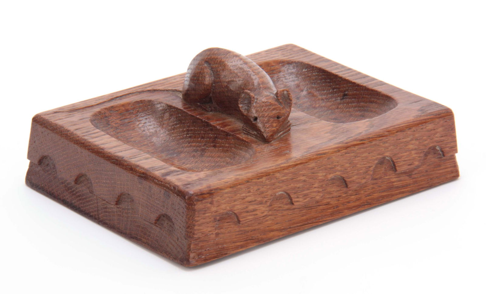 AN EARLY ROBERT MOUSEMAN THOMPSON OAK PIN TRAY of: AN EARLY ROBERT MOUSEMAN THOMPSON OAK PIN TRAY of rectangular form with arcaded moulded edge and carved mouse trademark between two oval dished sides 13.5cms by 10cms.