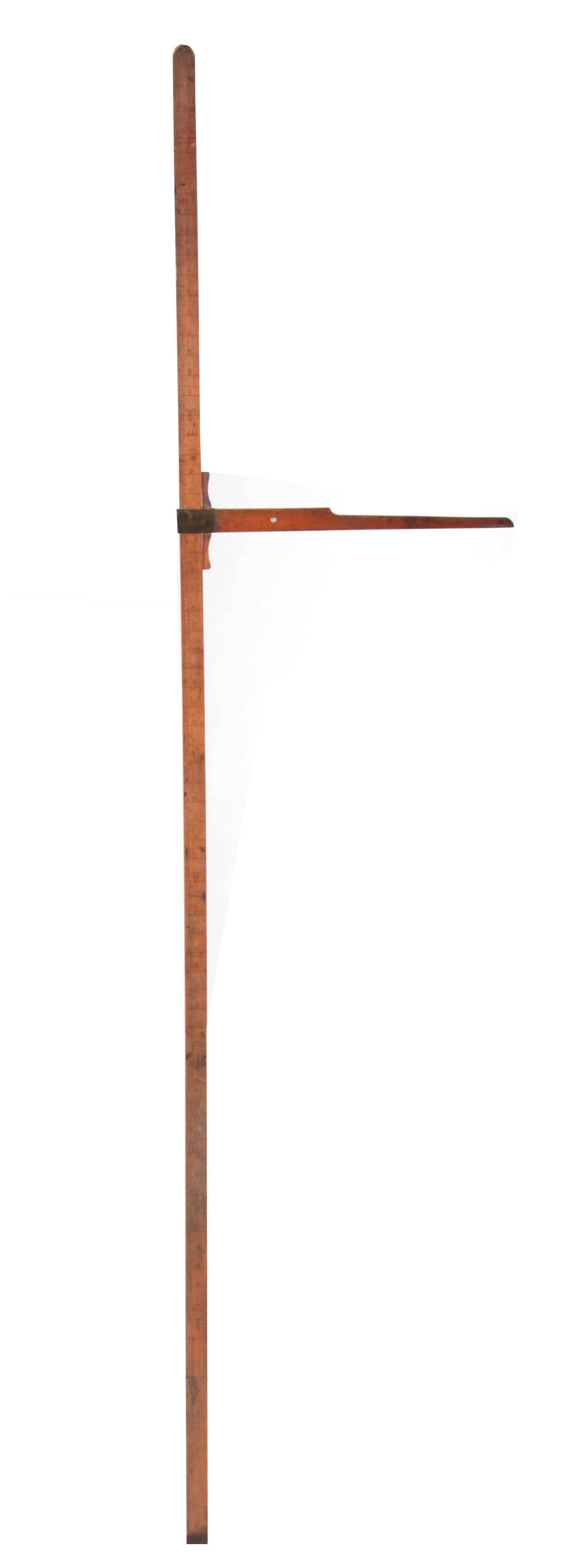 A LATE 19TH CENTURY BOXWOOD HORSE MEASURE having a: A LATE 19TH CENTURY BOXWOOD HORSE MEASURE having a sliding arm with a brass-framed bubble level on a calibrated pole, one side with hands the other feet and inches on brass tipped end 199cm high