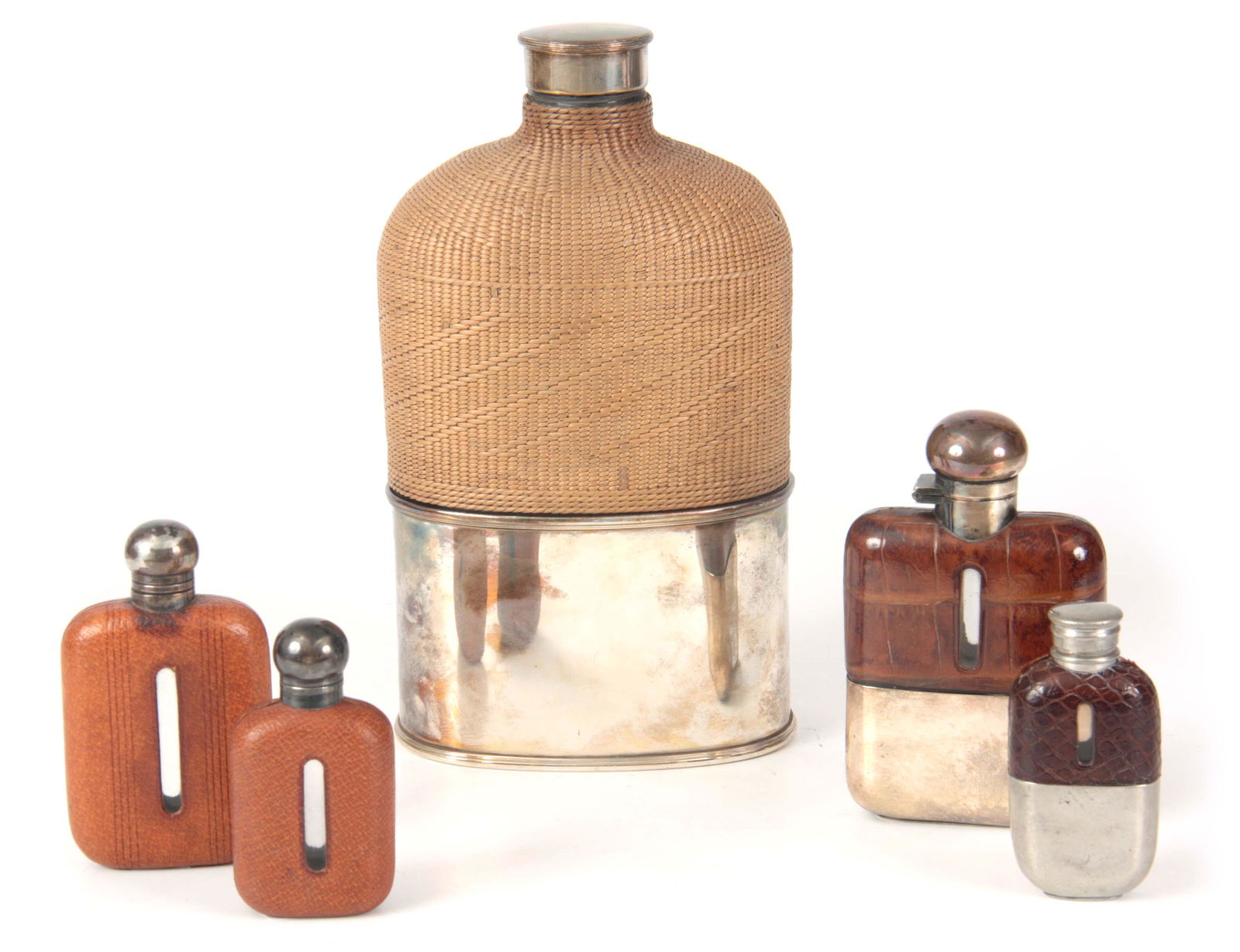 A COLLECTION OF FIVE HUNTING HIP FLASKS all silver: A COLLECTION OF FIVE HUNTING HIP FLASKS all silverplated and of various sizes with crocodile skin and leather, the oversized flask having woven whicker-work 22cm high (5)