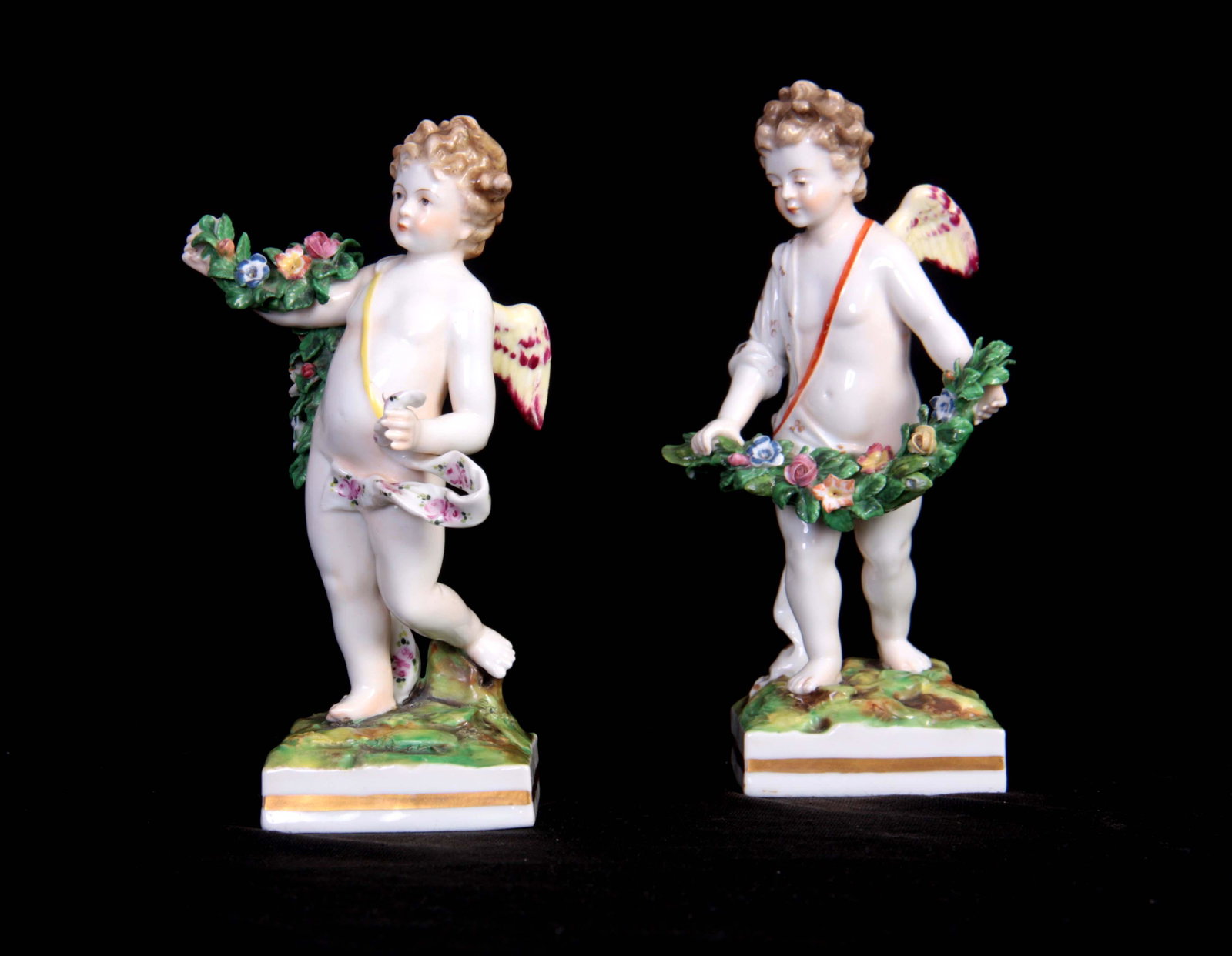 A PAIR OF EARLY 19TH CENTURY DERBY STYLE FIGURES p: A PAIR OF EARLY 19TH CENTURY DERBY STYLE FIGURES probably Samson, Paris depicting cherubs holding flower sprays, mounted on square bases, applied transfer marks beneath 16cm high.