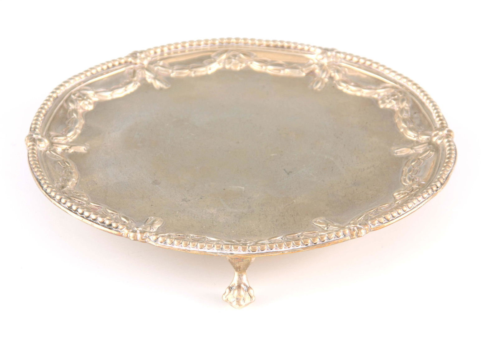 A GEORGE III SILVER SALVER with reed-edged border and: A GEORGE III SILVER SALVER with reed-edged border and embossed floral swags, raised on three ball and claw feet 17.5cm diameter, app. weight 270g (8.6 troy oz.) - Robert Jones I. London, 1774