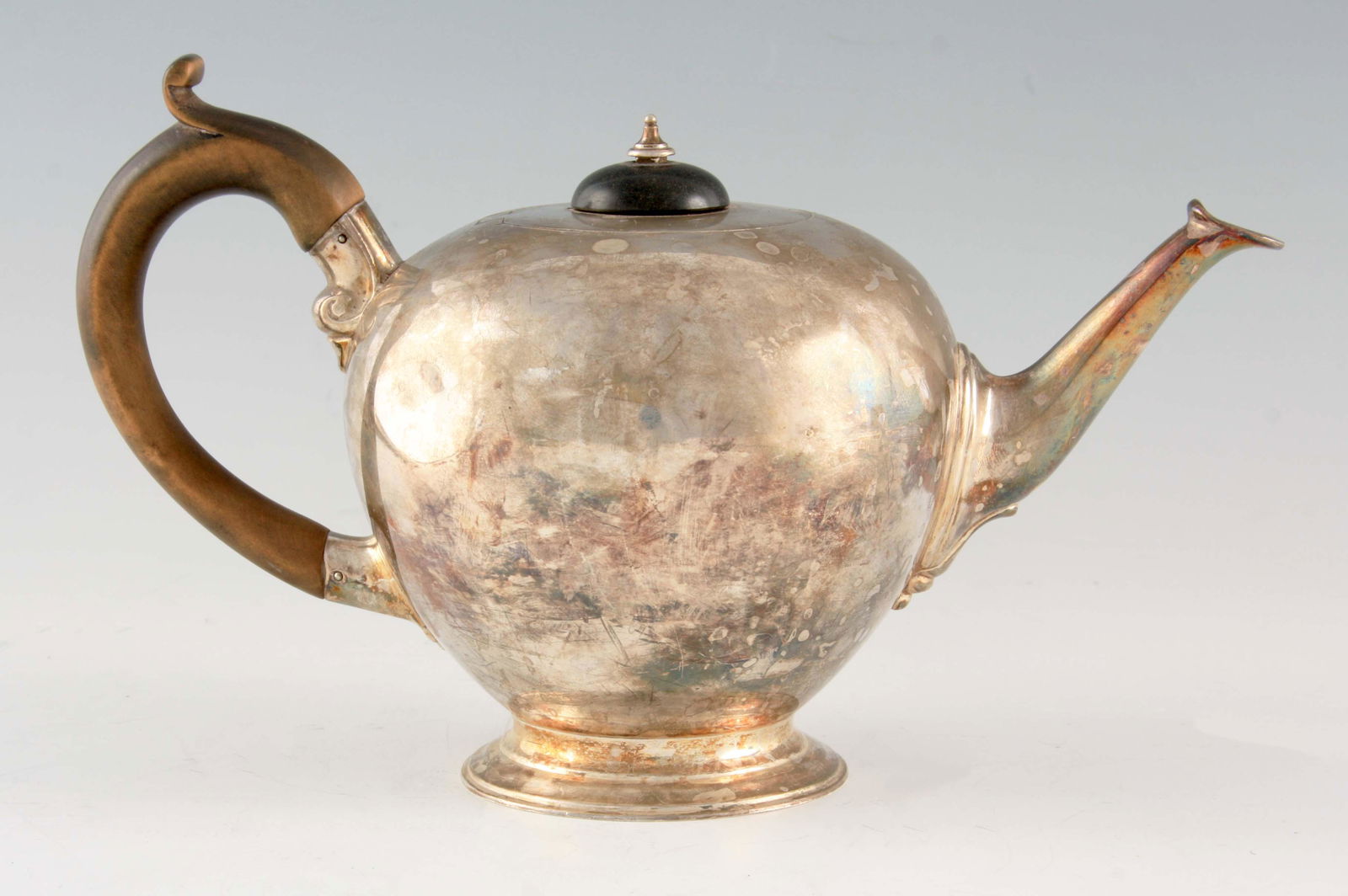 A VICTORIAN SILVER TEAPOT of bulbous form with hardwood: A VICTORIAN SILVER TEAPOT of bulbous form with hardwood handle and finial raised on a circular foot 13.5cm high, app. weight 442g, (14 troy oz.) - Charles Stuart Harris, London. 1898