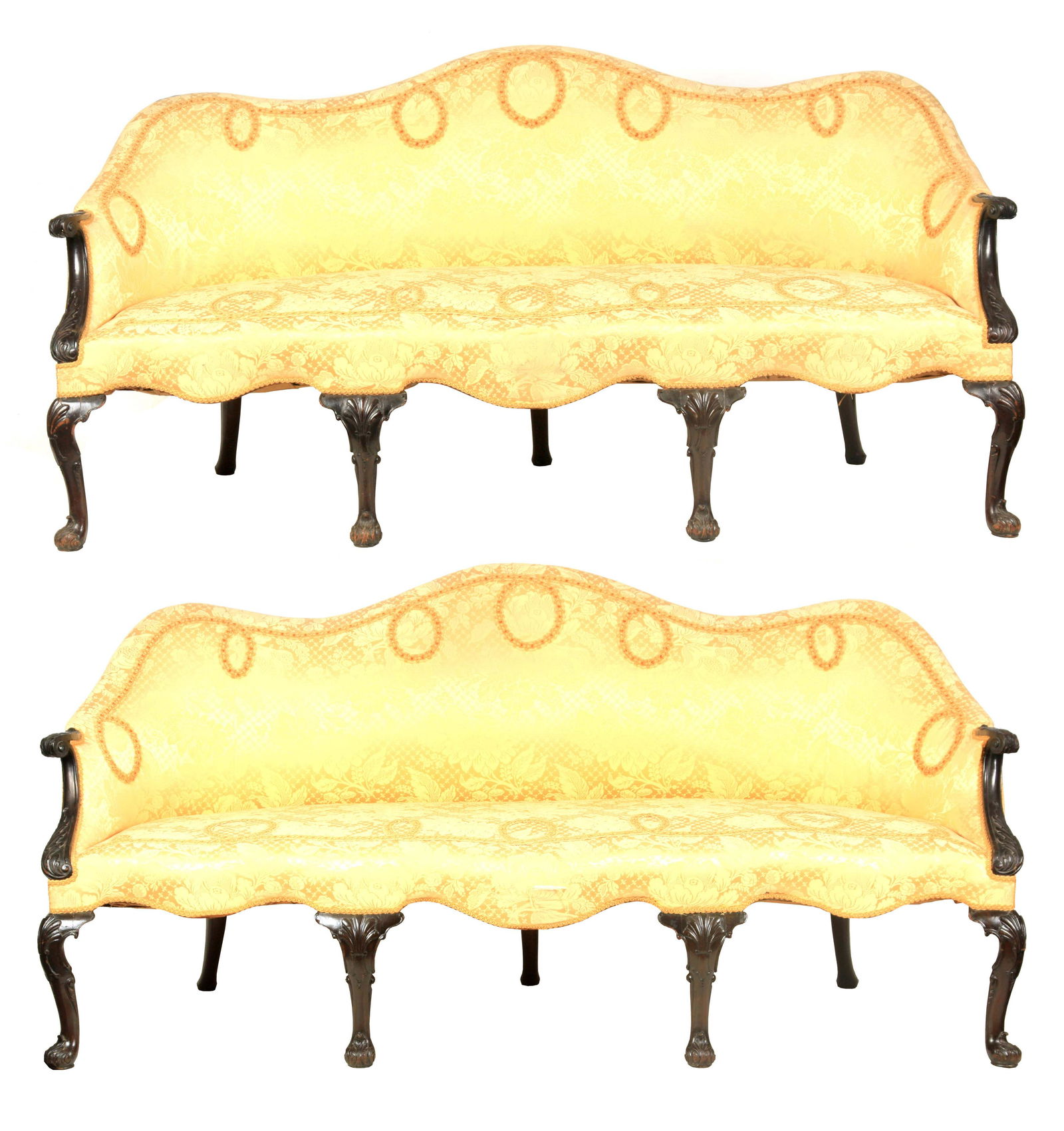 A FINE PAIR OF GEORGE III MAHOGANY CHIPPENDALE STYLE: A FINE PAIR OF GEORGE III MAHOGANY CHIPPENDALE STYLE CAMEL-BACK THREE SEATER SETTEES with sweeping leaf carved arms above serpentine shaped seat rails, standing on shell carved cabriole legs with scro