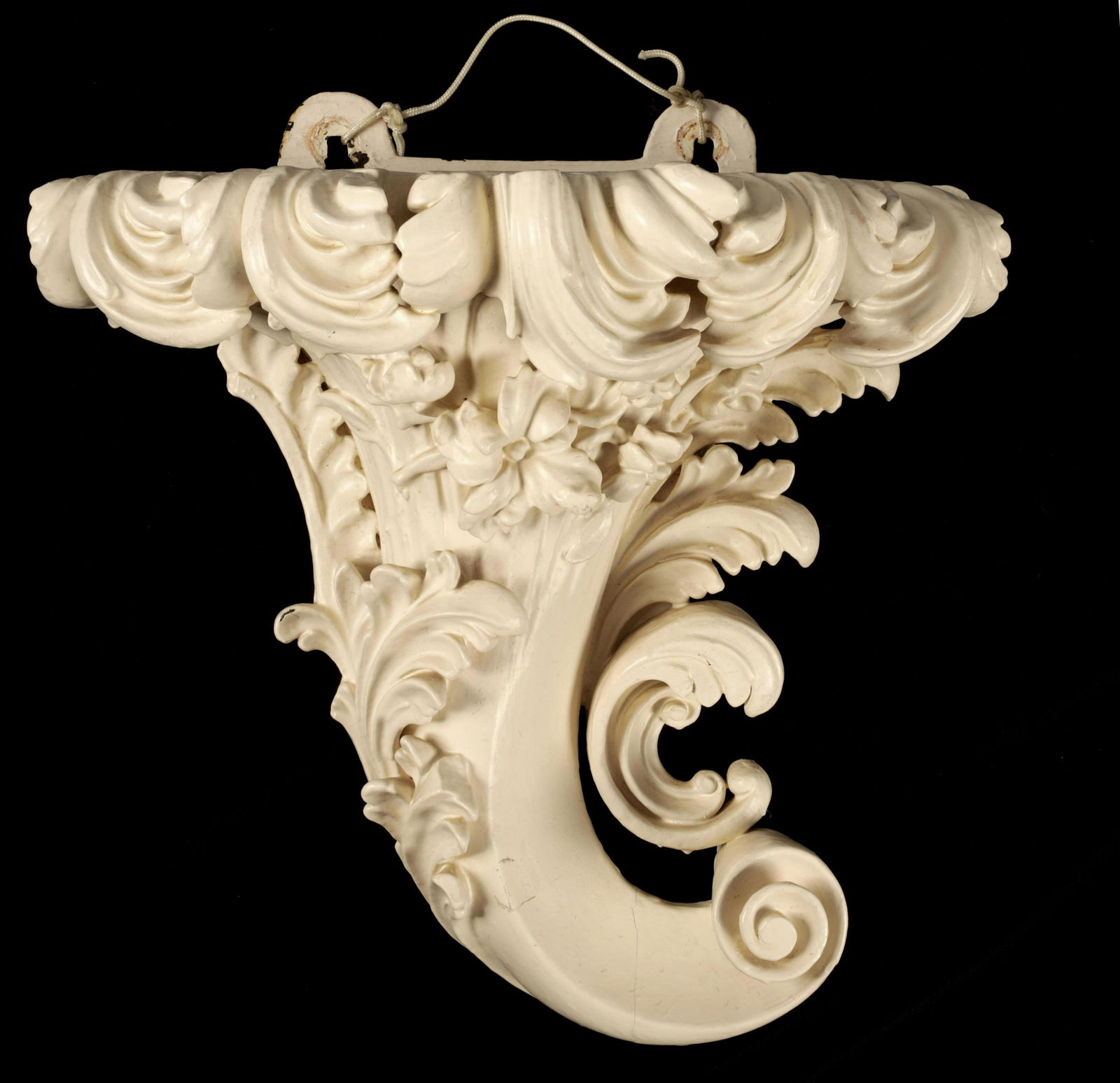 A FINE GEORGE III PAINTED CARVED MAHOGANY ROCOCO H: A FINE GEORGE III PAINTED CARVED MAHOGANY ROCOCO HANGING WALL BRACKET IN THE MANNER OF WILLIAM KENT of cornucopia shape carved in high relief with scrolling leaf work and flower head decoration 40cm h