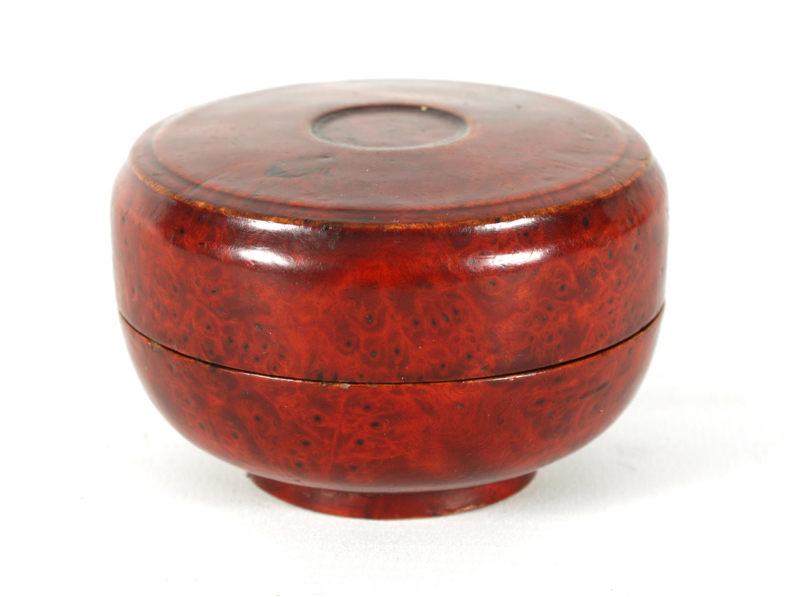 A 19TH CENTURY CHINESE BURR-WOOD TURNED LIDDED BOX: A 19TH CENTURY CHINESE BURR-WOOD TURNED LIDDED BOX with red laquer finish. (8cm diameter 5cm high )