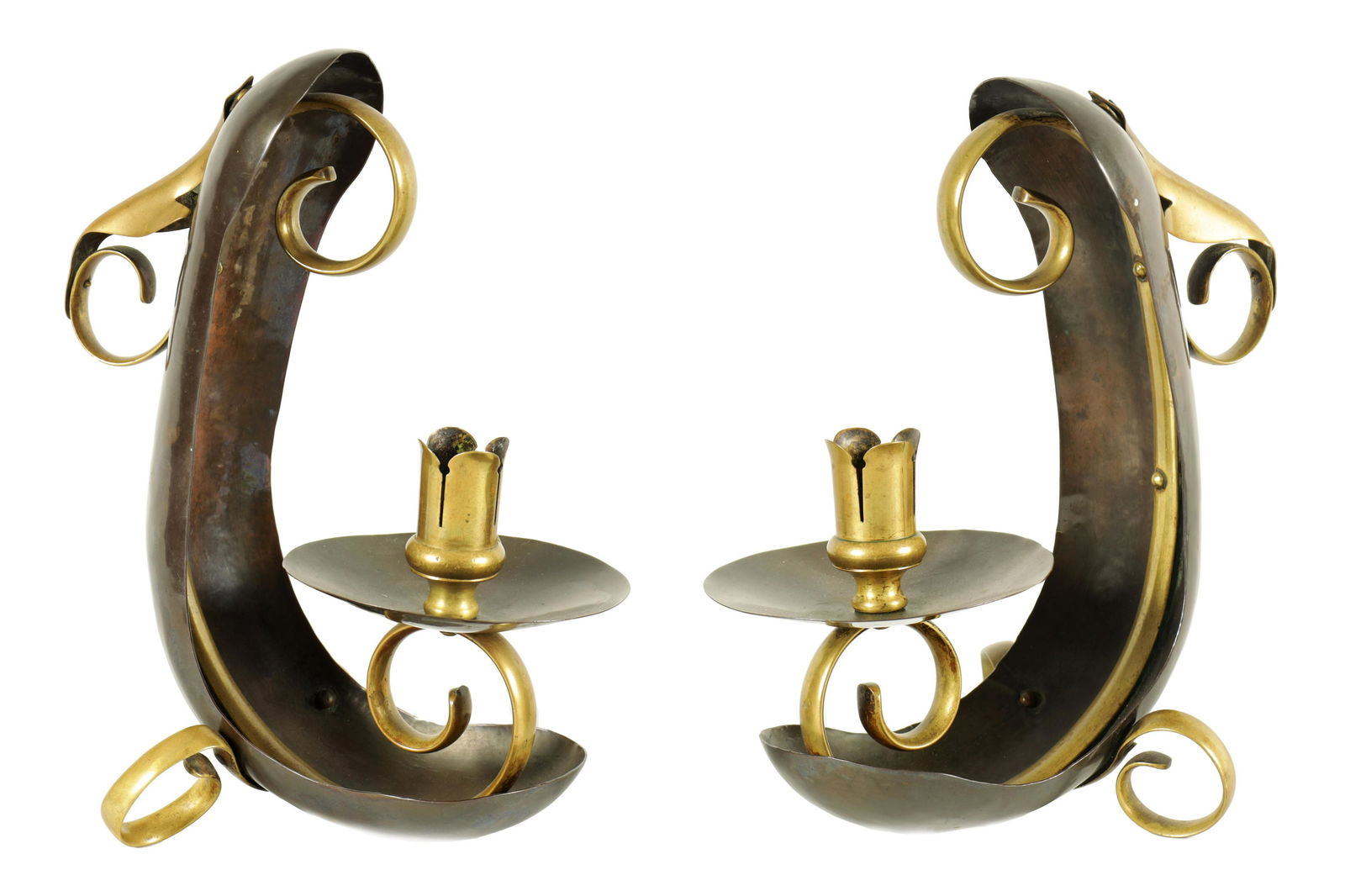 ATTRIBUTED TO WILLIAM ARTHUR SMITH BENSON A STYLISH PAIR OF ARTS AND CRAFTS PATINATED COPPER AND: ATTRIBUTED TO WILLIAM ARTHUR SMITH BENSON A STYLISH PAIR OF ARTS AND CRAFTS PATINATED COPPER AND BRASS CHAMBER CANDLESTICKS the curved boat shaped bodies on scrolled feet with matching centre and leaf