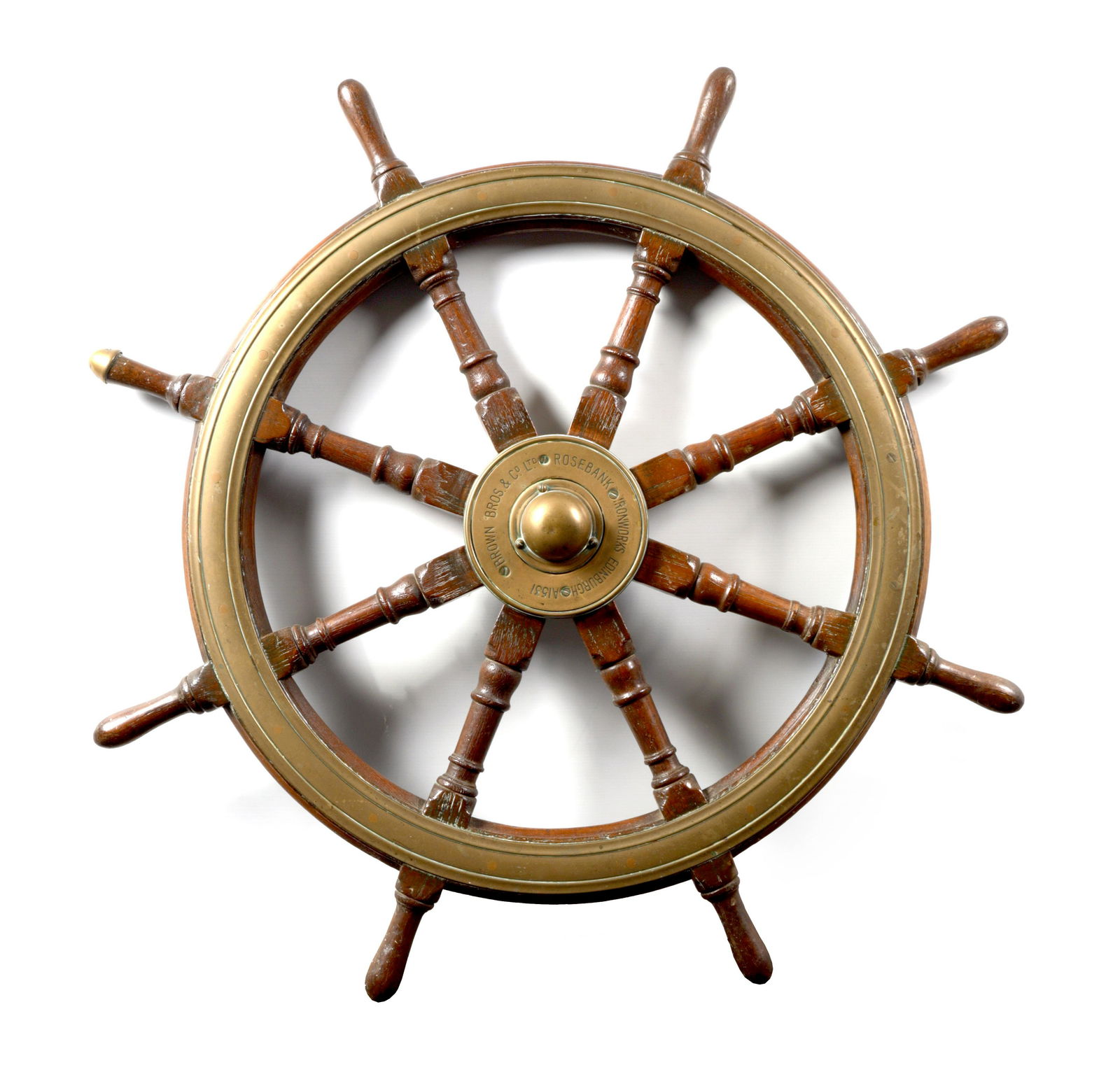 A LATE 19TH CENTURY BRASS MOUNTED OAK SHIP'S WHEEL BY BROWN BOTHERS, EDINBURGH: A LATE 19TH CENTURY BRASS MOUNTED OAK SHIP'S WHEEL BY BROWN BOTHERS, EDINBURGH having eight turned spinials surrounded by a moulded brass bound frame with centre brass mount inscribed "BROWN BROS. LTD