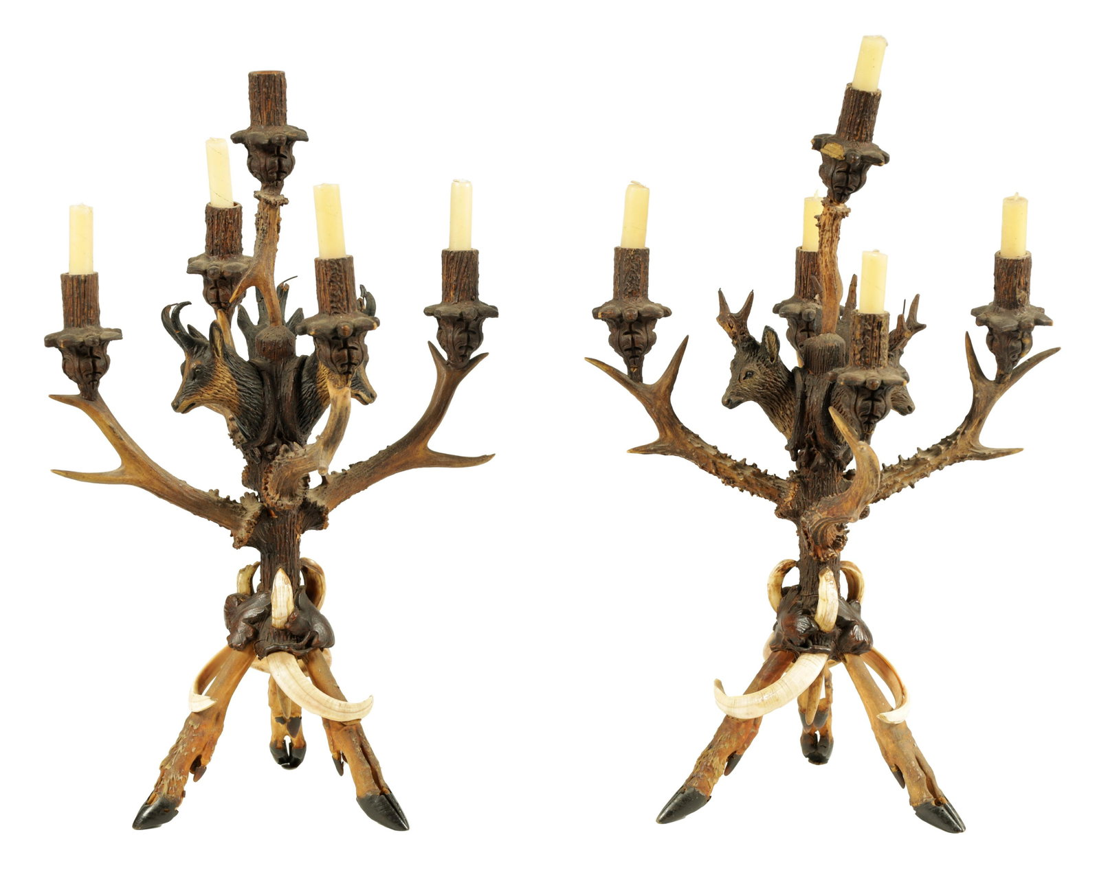 AN UNUSUAL PAIR OF 19TH CENTURY BLACK FOREST POLYCHROME CARVED WOOD, ANTLER HORN AND BOAR'S TUSK: AN UNUSUAL PAIR OF 19TH CENTURY BLACK FOREST POLYCHROME CARVED WOOD, ANTLER HORN AND BOAR'S TUSK FIVE BRANCH CANDELABRA of naturalistic design raised on tripod deer's leg and hoof feet bases. (53.5cm 