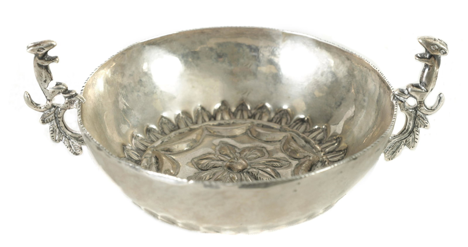 AN 18TH CENTURY SPANISH SILVER TEMBLADERA WINE TASTER: AN 18TH CENTURY SPANISH SILVER TEMBLADERA WINE TASTER with embossed base and pierced squirrel side handles, circa 1740 (7.8cm diameter, 10.2cm including handles )