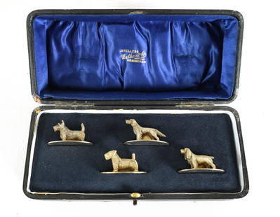 A CASED SET OF FOUR SILVER GILT DOG MENU HOLDERS: A CASED SET OF FOUR SILVER GILT DOG MENU HOLDERS comprising hound, spaniel, and terriers mounted on oval bases, total approx weight 81g - by William Suckling (3) and TS (1), Birmingham, 1931-32. (4.2c