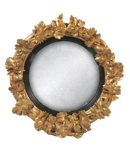 A LATE 19TH CENTURY GILTWOOD CIRCULAR WREATH CONVEX HANGING WALL MIRROR: A LATE 19TH CENTURY GILTWOOD CIRCULAR WREATH CONVEX HANGING WALL MIRROR decorated with a carved leaf, ebonised slip and convex mirror plate.