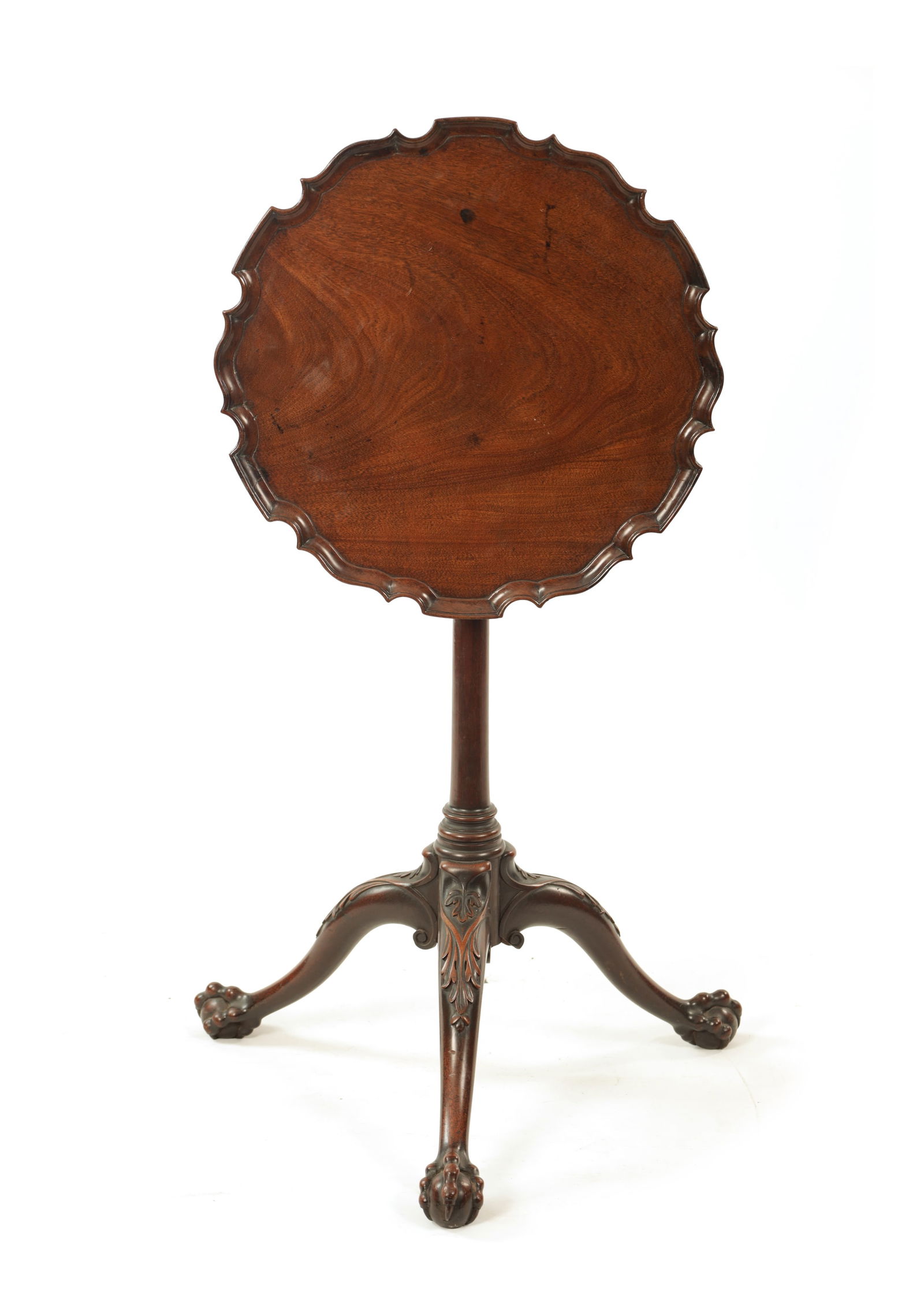 A MID 18TH CENTURY MAHOGANY TILT-TOP TRIPOD TABLE IN THE MANNER OF THOMAS CHIPPENDALE: A MID 18TH CENTURY MAHOGANY TILT-TOP TRIPOD TABLE IN THE MANNER OF THOMAS CHIPPENDALE with pie crust moulded edge tilt top above a slender tapering stem supported on leaf carved cabriole legs with bal
